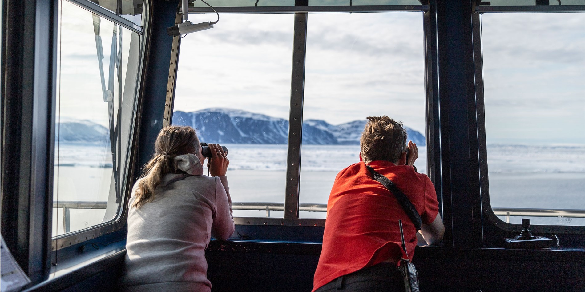 Guest and crewmember using binoculars in observation room - Photo Credit: Genna Roland